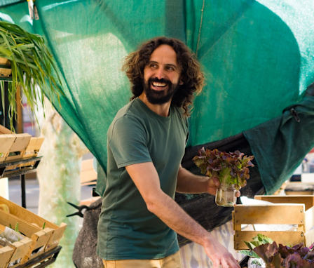 Happy man selling produce at an outdoor market